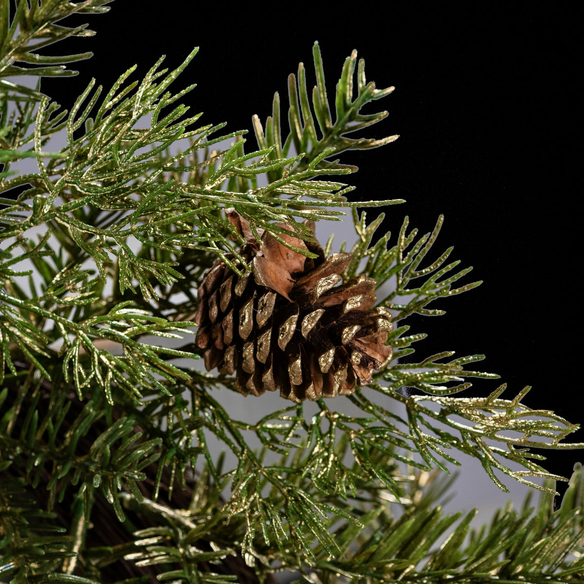 Couronne de sapin artificielle vert et or 45 cm, gros plan sur une pomme de pin et les aiguilles pailletées