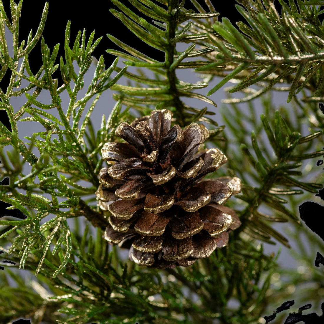 Branche de sapin artificielle vert et or 78 cm, gros plan sur une pomme de pin et les aiguilles pailletées